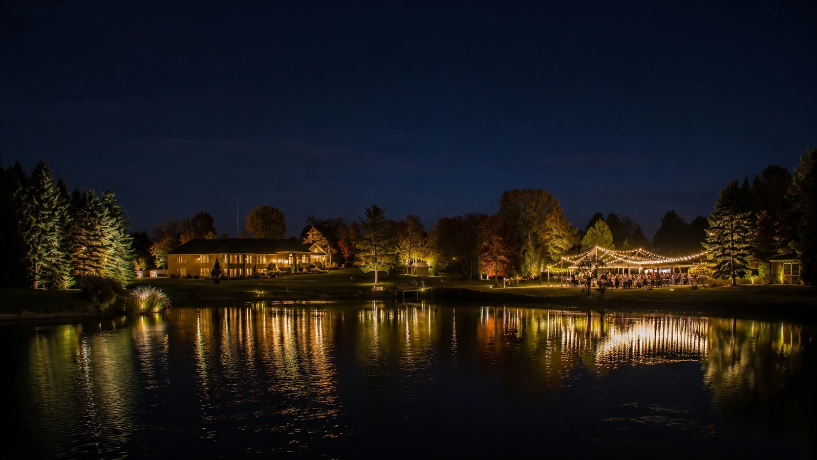 Illuminated estate and reception reflected in the pond at night